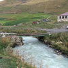 Ramshackle bridge over a fast flowing river Ushguli Georgia
