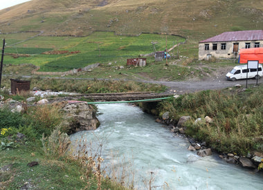 Ramshackle bridge over a fast flowing river Ushguli Georgia