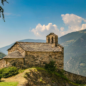 Stone church on a hill with mountains in the background on a sunny day, Andorra