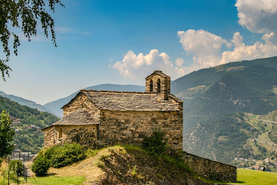Stone church on a hill with mountains in the background on a sunny day, Andorra