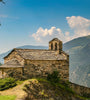 Stone church on a hill with mountains in the background on a sunny day, Andorra