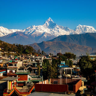 View of the snow covered peak of Annapurna with village in the foreground, Nepal