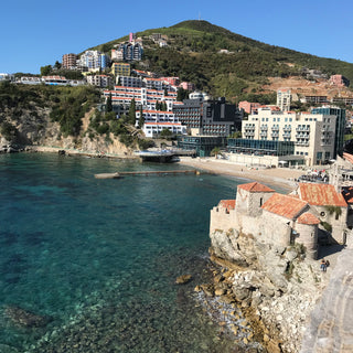 Coastline and beach in Budva, Montenegro with turquoise sea and a bright blue sky  