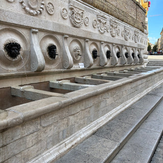 Calamo Fountain in Ancona, Italy. The Fountain features thirteen spouts, twelve covered by bronze masks, which represent satyrs and fauns.