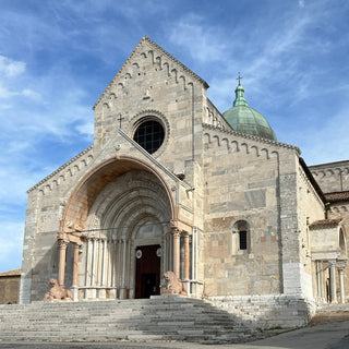 White stone facade of Cathedral of St. Cyriacus in Ancona Italy. The entrance is formed of a round arch with 4 columns