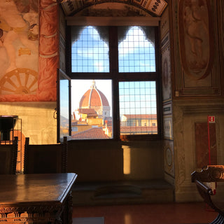 The dome of Florence Cathedral seen through an open window of the Vecchio Palace