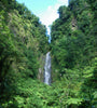 A waterfall with steep cliffs on either side covered in bright green vegetation