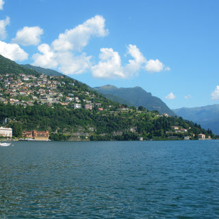 A view across Lake Como Italy with clear blue water and houses on the hillside