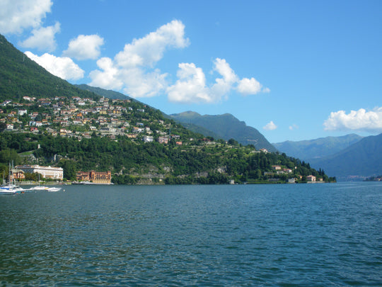 A view across Lake Como Italy with clear blue water and houses on the hillside