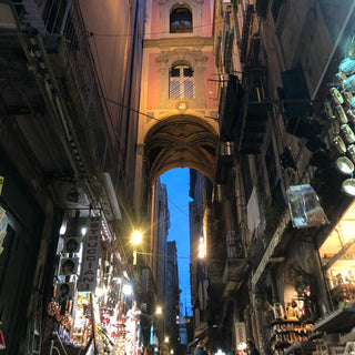 Narrow street with shops on either side in Naples Italy