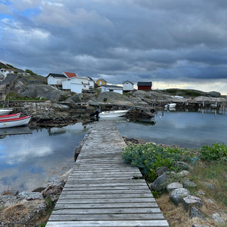 Wooden jetty in cove with small boats on Vrångö island, Sweden 